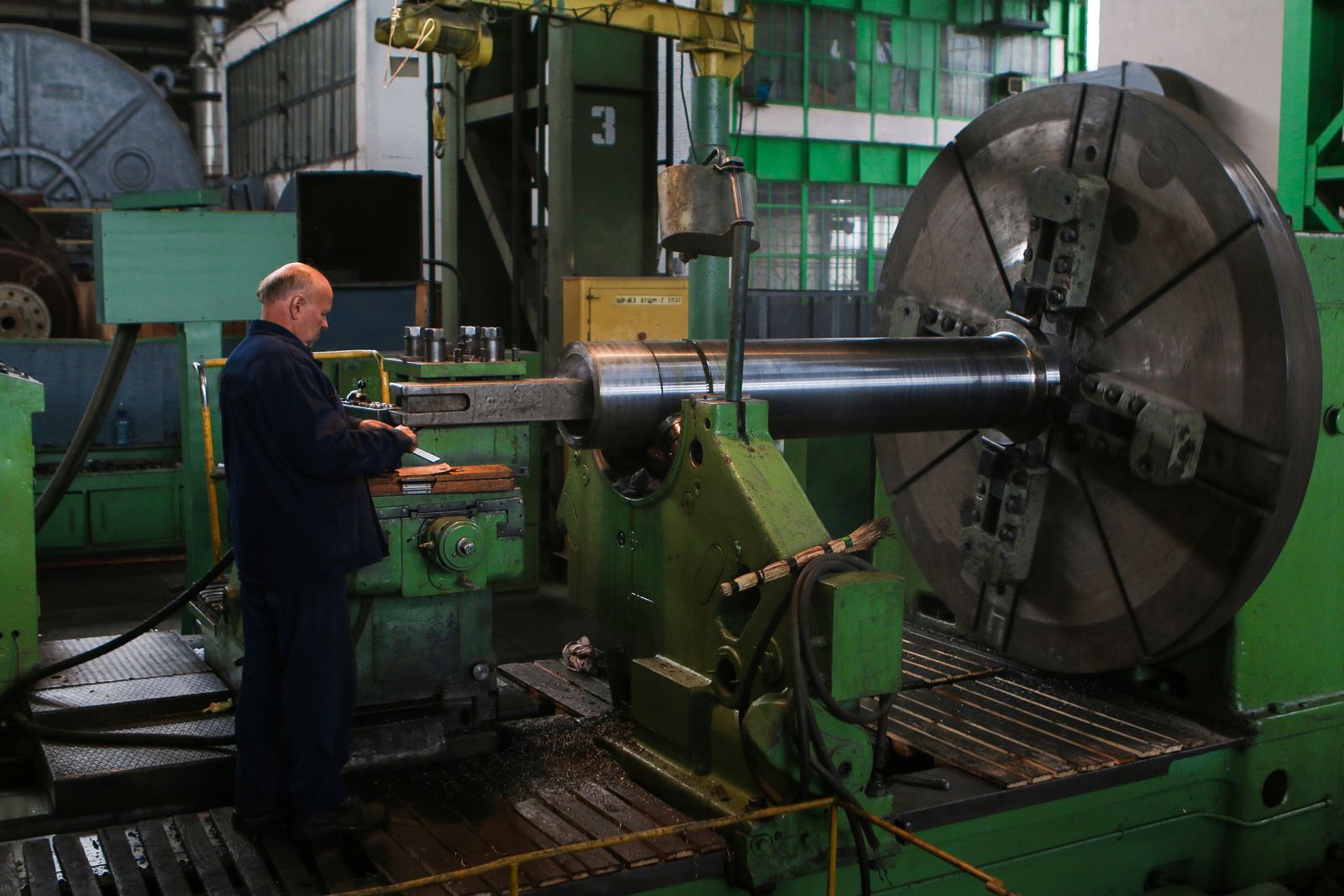 Machinist working at a large lathe in an engineering works